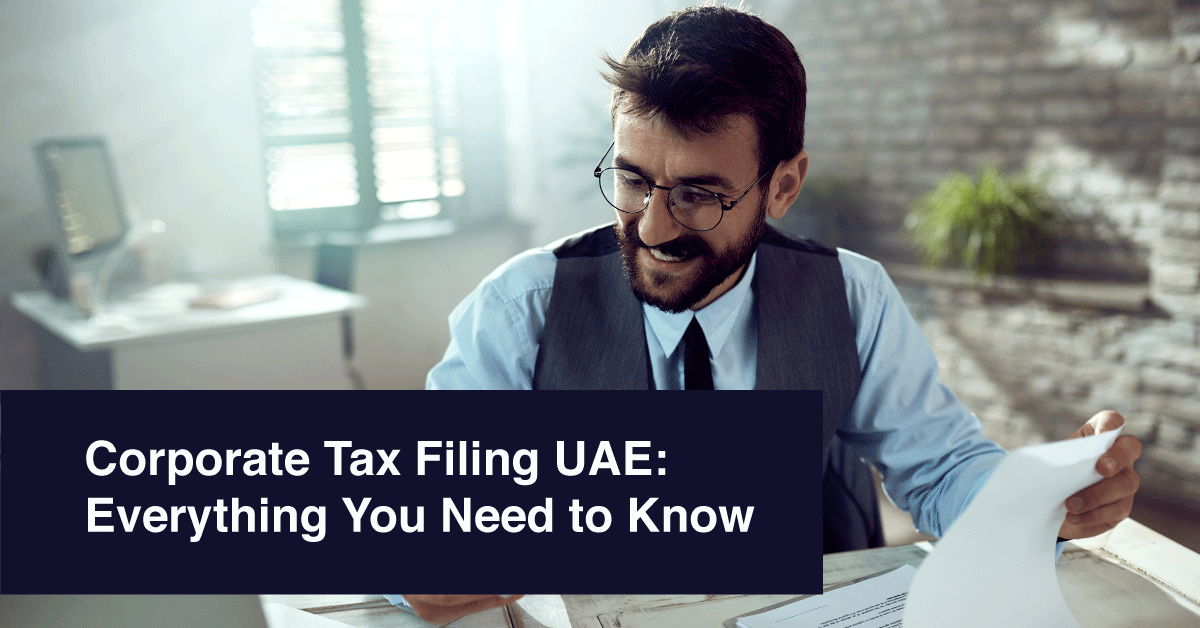 Corporate tax advisor in UAE reviewing documents at desk with headline Corporate Tax Filing UAE: Everything You Need to Know